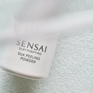 Close up of Silk Peeling Powder bottle on top of poured product showcasing the texture